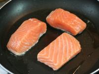 Heat the oil in a pan and put small salmon steaks...