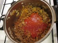 Pour in tomato puree, blend well....