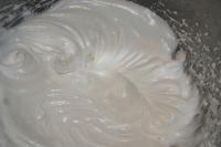 While cake is in the oven, whisk egg whites with...