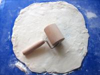 Use a rolling pin to spread puff pastry on floured...