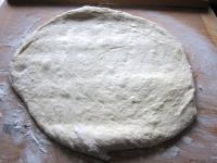 Use a rolling pin to spread the dough on a floured...