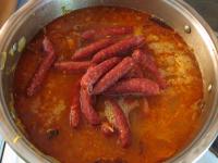 Pour in water, add sausages and cook the soup...
