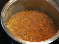 Pour wine into the meat and mix tomato paste in....