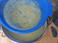 Strain the soup through a colander with larger...
