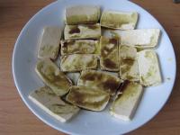Cut the tofu into slices. Spread half of it in a...