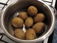Cook potatoes in their skins, drain them, allow...