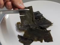 Cut the seaweed slices crosswise with scissors in...