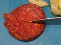 Cut the thin wheels of salami in half....