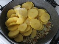 Add potatoes to the fried onion, salt and add a...