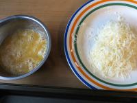 Whip the eggs and grate the cheese....